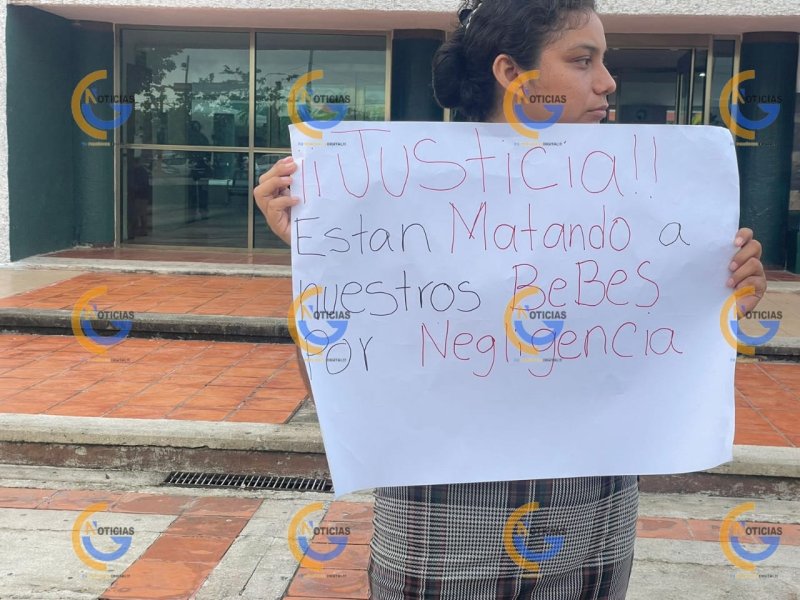 “Justicia están matando a nuestros bebés por negligencia”, se lee en una cartulina que sostiene una joven y una madre de familia, que se están manifestando afuera de las instalaciones de la clínica de Ginecopediatria.