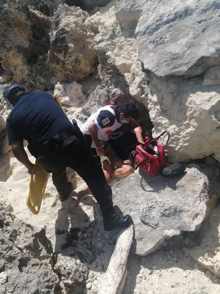 Turista pierde el equilibrio y cae entre las rocas de la playa